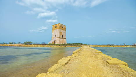 Time-lapse-shot-of-old-tower-at-Port-of-Trapani-with-jetty-during-sunny-day-in-Sicily