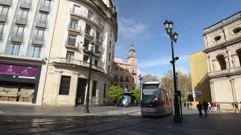 Tram-of-Sevilla-driving-through-the-streets-of-the-old-town-of-Seville,-Spain