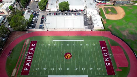 Fairfax-High-School-football-field-during-a-soccer-match---ascending-aerial-tilt-down-view