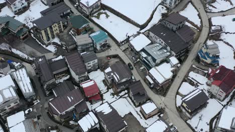Luftaufnahmen-Von-Autos-In-Japan,-Die-Im-Winter-Durch-Das-Dorf-Nozawa-Onsen-In-Nagano,-Japan,-Fahren