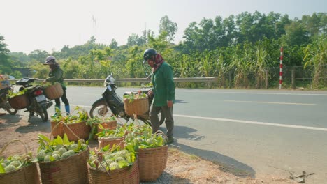 Tracking-Shot-Of-A-Gentlemen-Transporting-Crates-Of-Fresh-Produce-On-A-Motorbike-While-Others-Load-Their-Own-Bikes-At-The-Chi-Lang-district,-Lang-Son-province,-Vietnam