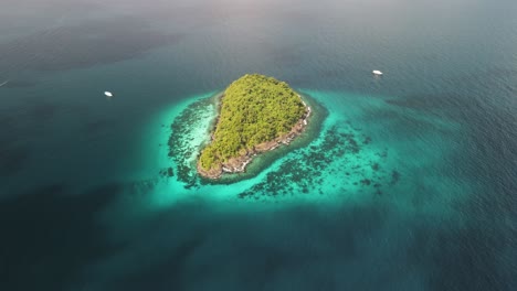 High-angled-flyover-shot-of-a-small-island-near-Ko-Lipe,-Thailand-on-a-bright-clear-day