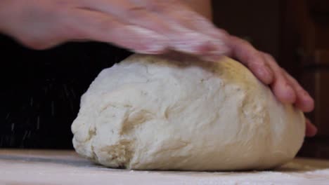 Male-hands-are-kneading-floured-dough-for-bread-in-homemade-bakery