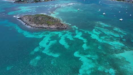 Aerial-over-shallow-clear-blue-waters-from-Pinel-Island-to-St