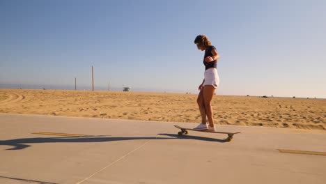 Sportliche-Junge-Frau-In-Freizeitkleidung,-Die-In-Einem-Sonnigen-Wüstenpark-Skateboard-Fährt