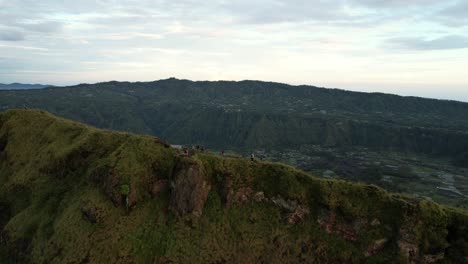 Luftaufnahmen-Von-Menschen,-Die-Bei-Sonnenaufgang-Auf-Einem-Bergrücken-In-Der-Nähe-Des-Kraters-Des-Vulkans-Mount-Batur-Auf-Bali-In-Indonesien-Wandern