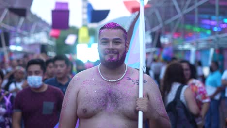 Close-up-of-caucasian-homosexual-with-collared-hair-and-pride-flag-during-a-march-in-the-city-against-discrimination