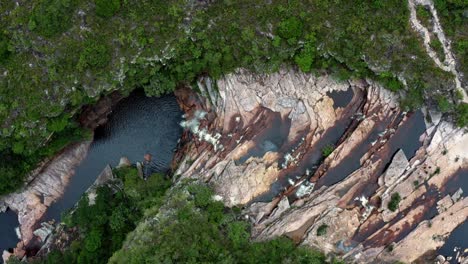 Aerial-drone-left-trucking-top-down-shot-of-the-incredible-Mosquito-Falls-surrounded-by-tropical-jungle-and-cliffs-in-the-Chapada-Diamantina-National-Park-in-Northeastern-Brazil-on-a-warm-summer-day