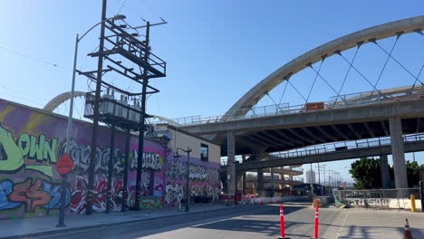 Establishing-Shot-of-Downtown-Industrial-Area,-Sixth-Street-Bridge-and-Street-Art-Wall-on-Clear-Sunny-Day-in-Los-Angeles