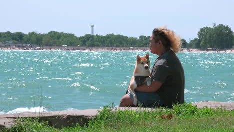 Young-Adult-Male-at-the-lake-with-his-dog-on-his-lap