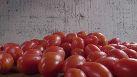 Many-red-ripe-tomatoes-on-a-wooden-surface-in-the-kitchen,-ready-to-be-used-for-cooking