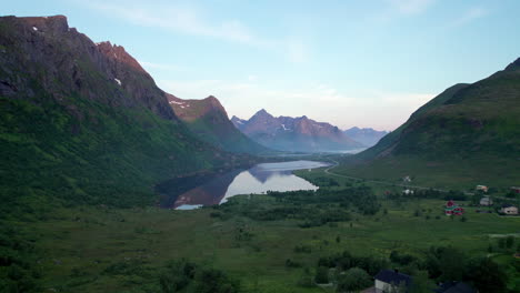 Midnight-sun-enlighten-Lofoten-Mountains-during-night-in-Summer,-Northern-Europe,-Tucking-Drone-shot