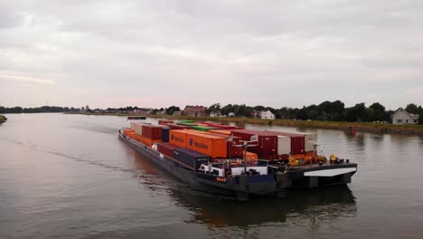 Luftaufnahme-Vom-Bug-Des-Maas-Schubschleppkahns,-Der-Frachtcontainer-Entlang-Des-Flusses-Noord-Transportiert