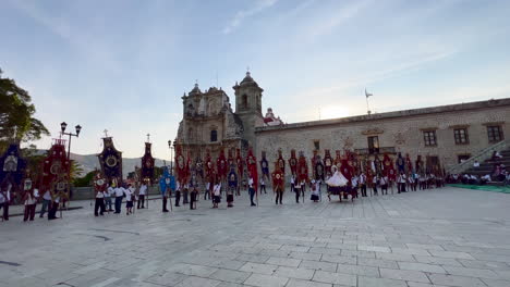 Traditional-Folklore-Parade-Event,-People-Colorful-Flags-and-Ornaments-at-Plaza-De-La-Danza-Oaxaca-Mexico,-Cultural-and-Religious-Activities-at-Outside-Courtyard-Esplanade,-Tourist-Show,-Dolly-View
