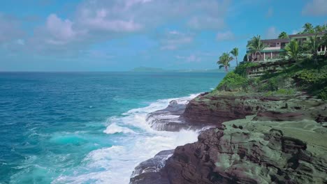 Aerial-view-of-rocky-cliffs-and-crashing-waves-in-Oahu-on-a-sunny-day