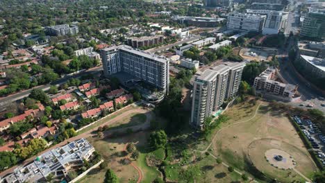 Parque-Verde-Que-Rodea-Edificios-Altos-Y-Hoteles-En-Sandton-Johannesburgo,-Antena