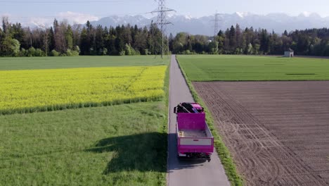 Drohnenaufnahme-Eines-Fahrenden-Lastwagens-Mit-Wunderschöner-Landschaft-Der-Schweizer-Berge