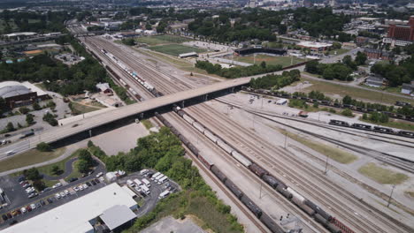 Aerial-hyperlapse-flying-over-the-trainyard-and-the-3rd-street-bridge-with-Lookout-Mountain-in-the-background-in-Chattanooga,-TN