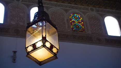 4K-Footage-of-a-ceiling-lamp-in-the-beautiful-Bahia-palace-with-the-fountain-in-Marrakesh,-Morocco,-Africa