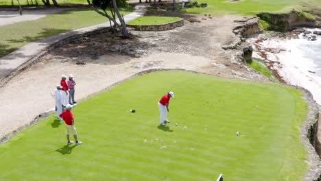 Golfers-in-tournament-with-red-shirts-on-the-tee-box,-Caribbean-golf-course