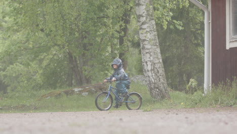 Zeitlupe---Ein-Kleines-Kind,-Das-Bei-Starkem-Regen-Fahrrad-Fährt