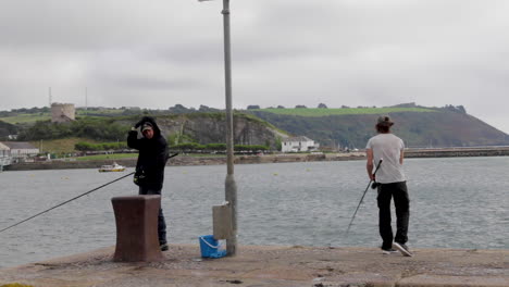 Two-sea-anglers-hoping-to-catch-fish-from-the-Plymouth-sound-in-the-English-county-of-Devon