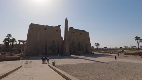 Turistas-Caminando-Cerca-Del-Obelisco-En-El-Templo-De-Luxor-En-Egipto-En-Un-Día-Soleado