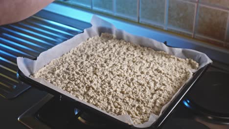 Adding-Cumin-To-Low-Fat-Oat-And-Cheese-Snack-In-A-Sheet-Pan-Before-Baking