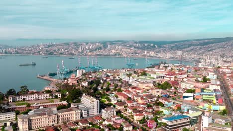 Luftparallaxe-Des-Farbenfrohen-Viertels-In-Playa-Ancha-Hill,-Des-Seehafens-Von-Valparaíso-Und-Der-Stadt-Am-Hang-Im-Hintergrund,-Chile