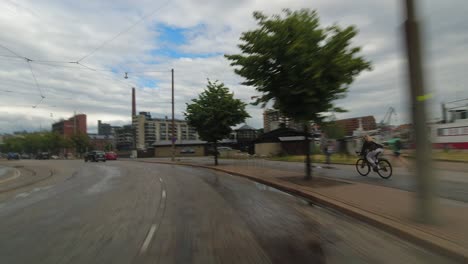 Cobbled-street-POV-drive-along-city-waterfront-beside-bicycle-lane