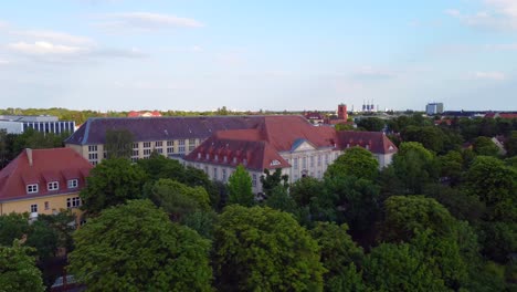 Daring-aerial-view-flight-fly-backwards-drone-footage-of-Prussian-State-Archives-of-Cultural-Heritage-dahlem-Berlin,-golden-hour-Summer-2022