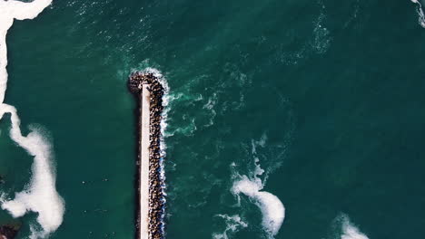 Pier-protected-from-thrashing-waves-by-dolosse-on-one-side