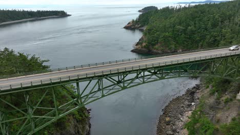 Drone-perspective-of-a-single-car-driving-across-Deception-Pass-in-Washington-State