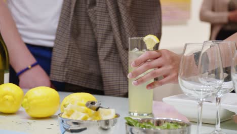 A-man-grabs-a-mojito-drink-that-was-served-to-him-at-a-fancy-art-gallery-exhibit