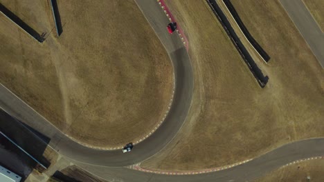 Rotational-aerial-view-of-racing-cars-turning-at-curve-of-racing-track