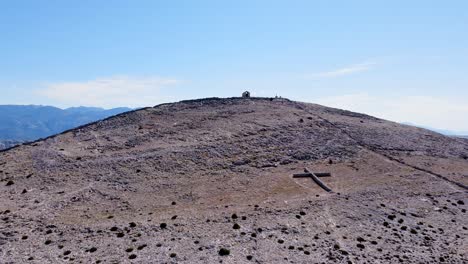 Aerial-view-of-a-mountain-top-with-a-big-cross-in-front