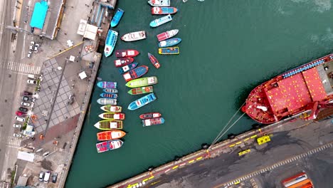 Aerial-view-over-water-fishing-boats-red-ship-Valparaiso-port-harbor-Chile-day