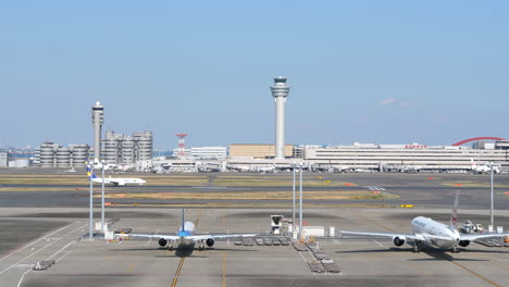 Panoramic-view-of-Haneda-airport-with-parked-planes-and-aircraft-taking-off