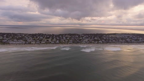 Wide-rising-drone-shot-of-beach-houses-on-the-coast-on-the-outer-banks-of-North-Carolina