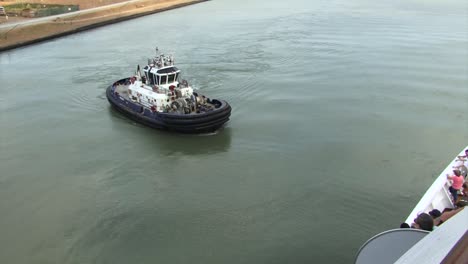Tugboat-at-Miraflores-Locks,-Panama-Canal,-approaching-the-cruise-ship
