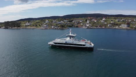 Car-and-passenger-ferry-sailing-Norwegian-fjord-with-signal-flags-ship-dressing-during-celebration---Aerial-profile-following