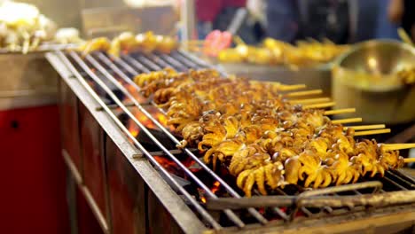 Grilled-Squid-on-a-charcoal-stove-at-Yaowarat-Road-Chinatown,-a-popular-travel-destination-in-Bangkok,-Thailand