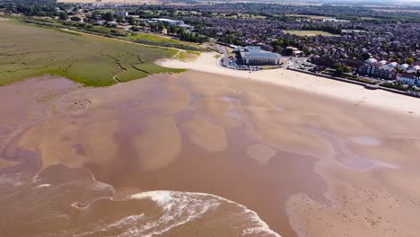 Aerial-descending-view-over-Grimsby-Cleethorpes-sandy-beach-shoreline-towards-leisure-centre-solar-panel-rooftop-property