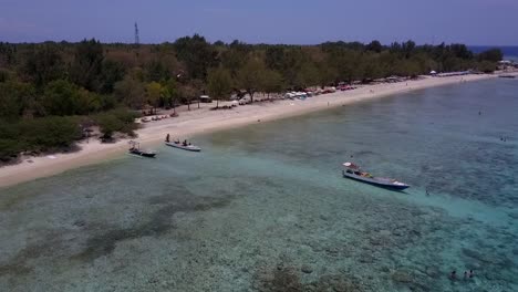 Locals-get-out-of-the-boat-Amazing-aerial-view-flight-subject-in-of-view-drone-footage-of-Gili-Trawangan-dream-beach-Indonesia-at-sunny-summer-daytime-2017-Cinematic-view-from-above-by-Philipp-Marnitz