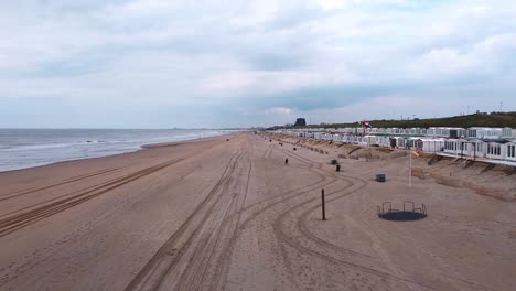 Drone-shot-of-North-sea-beach-with-cabins-on-the-right