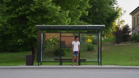 Hübscher-Srilankischer-Mann,-Der-An-Einer-öffentlichen-Bushaltestelle-Auf-Den-Bus-Wartet,-Handheld-Ansicht
