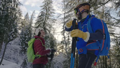 Skiing-man-and-woman-high-five-in-slow-motion-in-forest