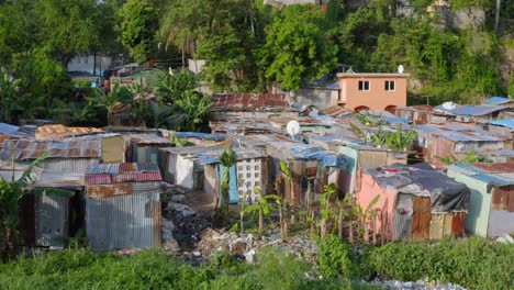 Aerial-backward-over-dilapidated-shacks-near-Ozama-river,-Santo-Domingo