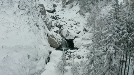 Aerial-dolly-of-small-waterfalls-in-snowcovered-wilderness