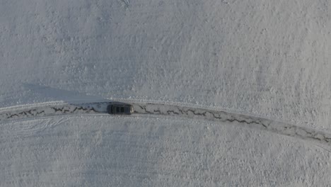 Ein-Schwarzer-Geländewagen-Fährt-Langsam-Durch-Einen-Verschneiten-Hügel